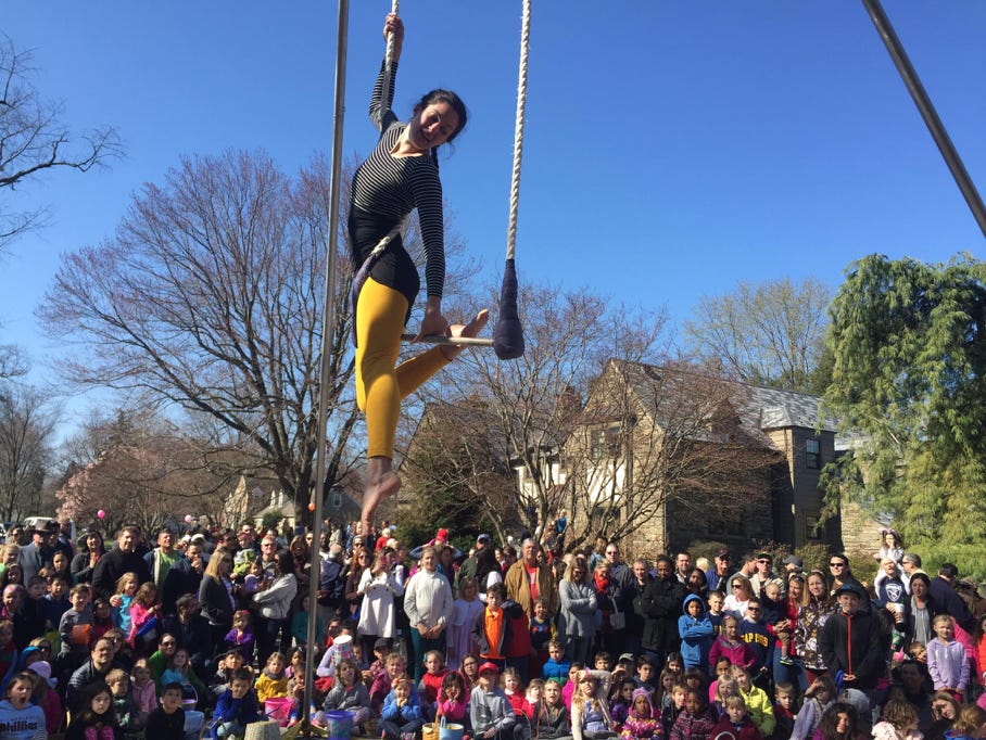 trapeze artist outdoors with large audience in spring