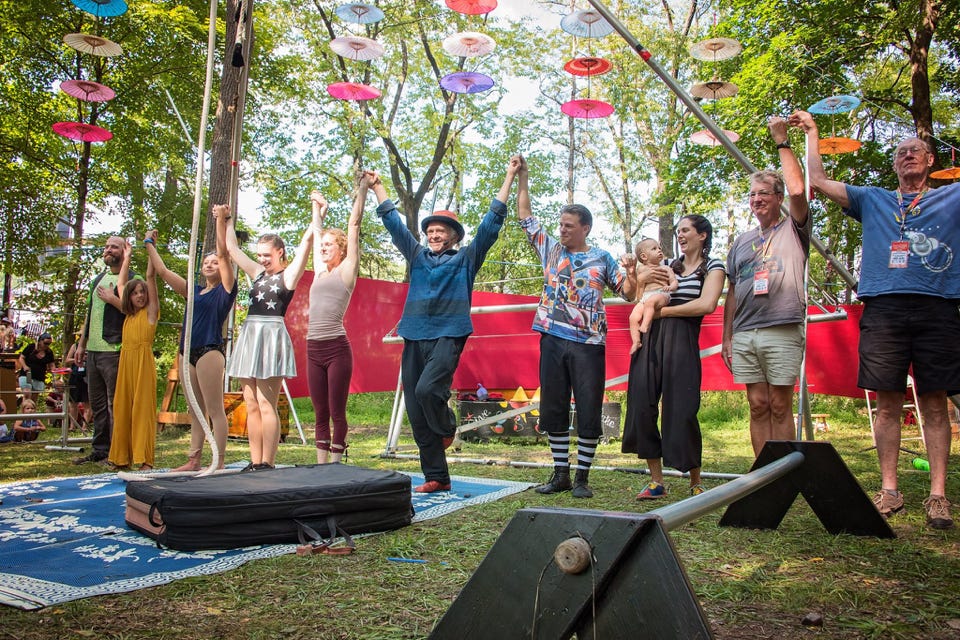 line of performers taking a bow in an outdoor festival