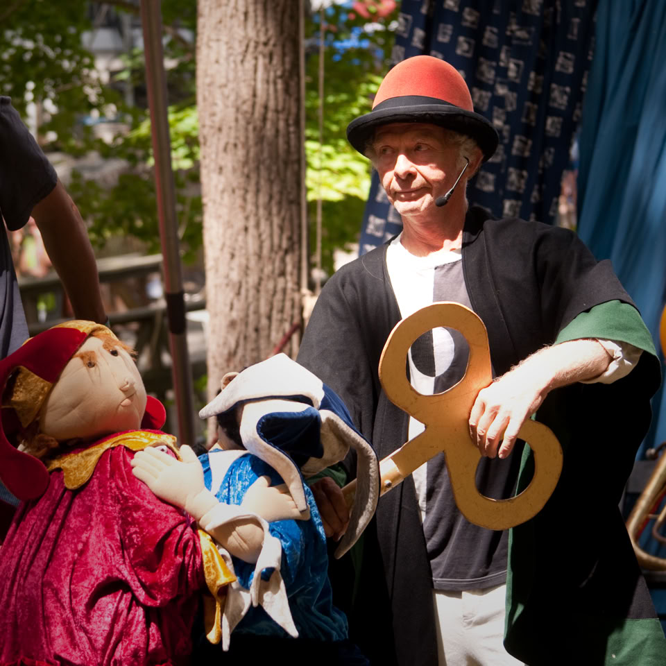 performer uses wind up key for a large puppet