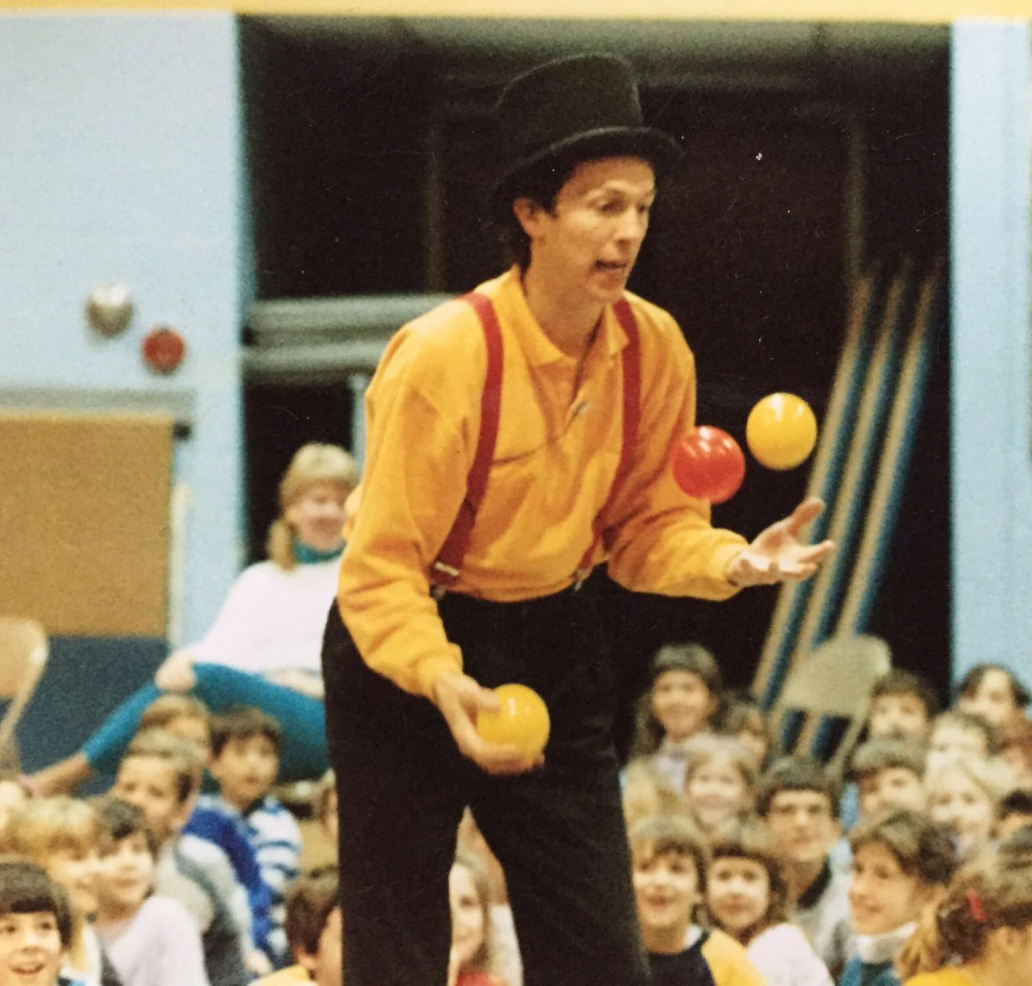 young nick gregory juggling balls in a school