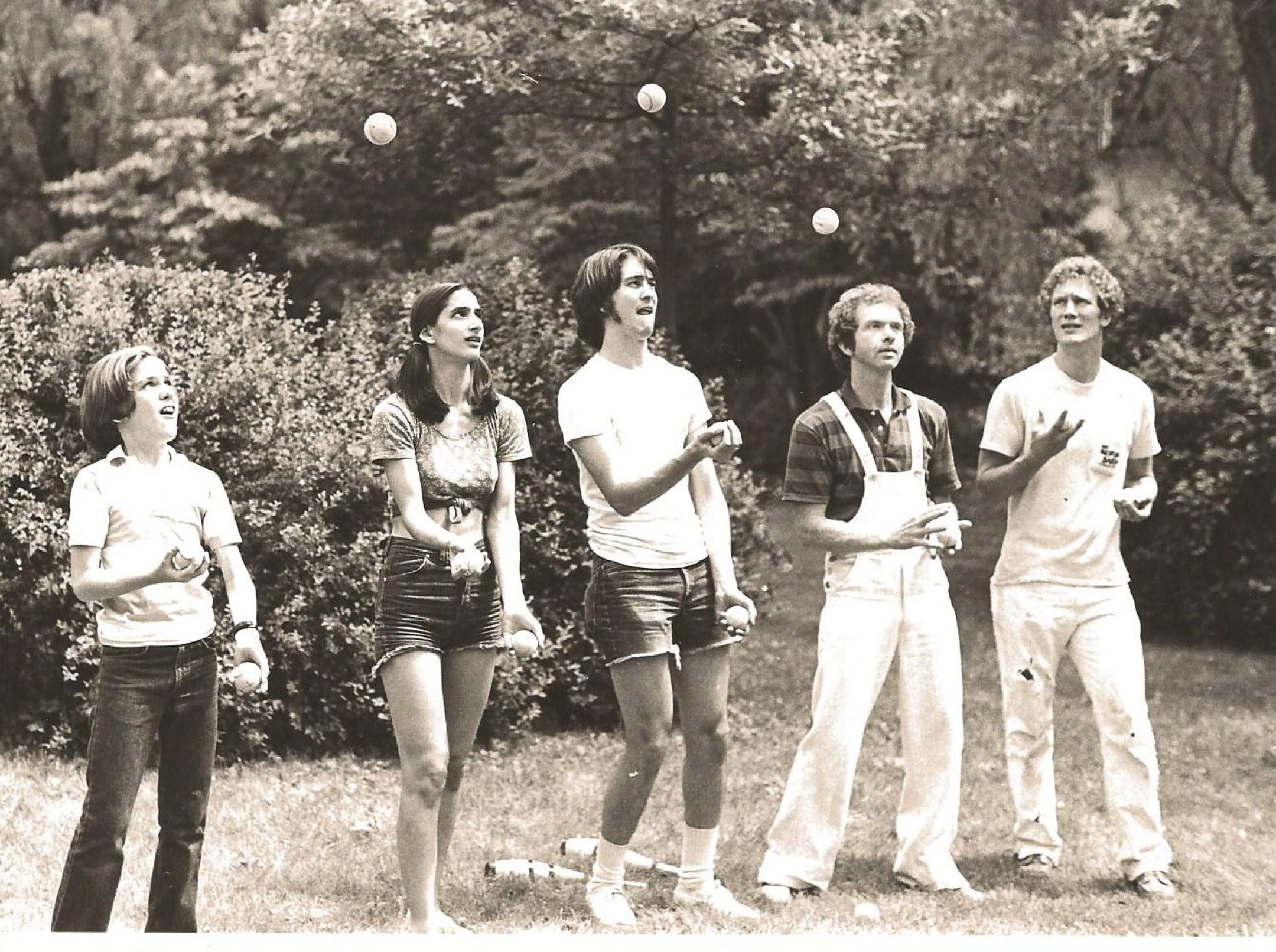 group of 5 jugglers throwing balls b&w