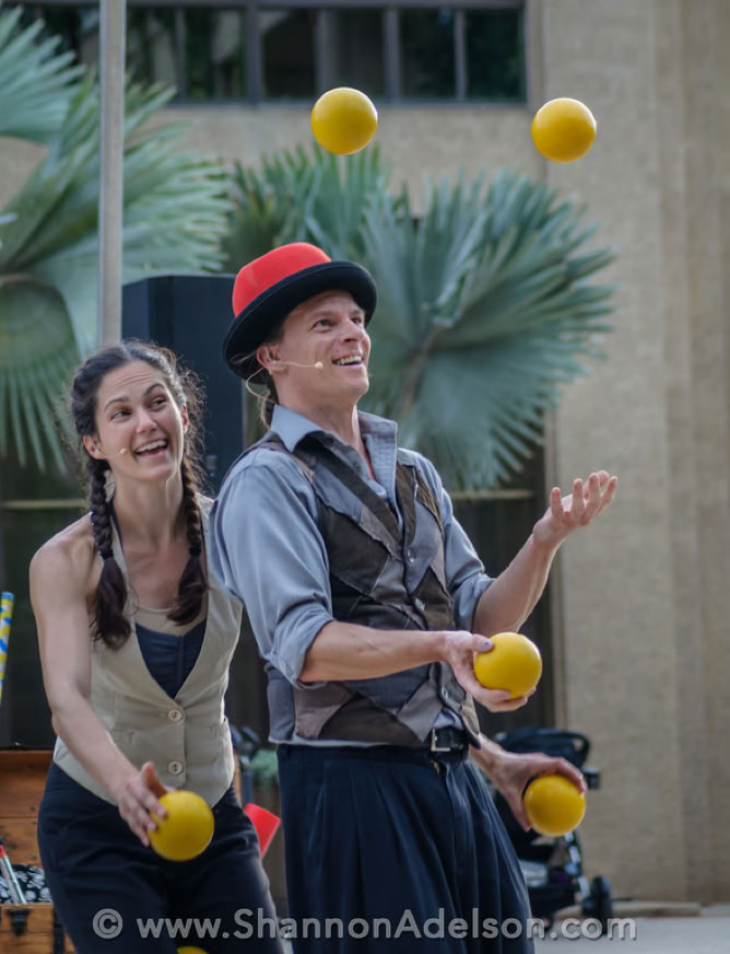 2 ball jugglers with palm tree in background