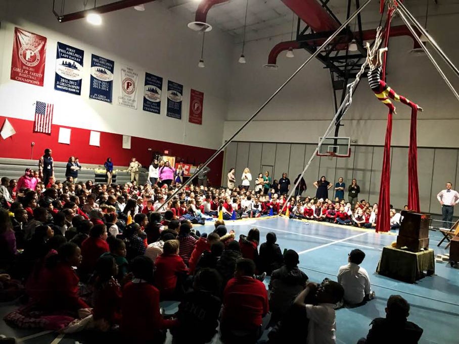 large assembly program audience in gym watching aerial silk performance