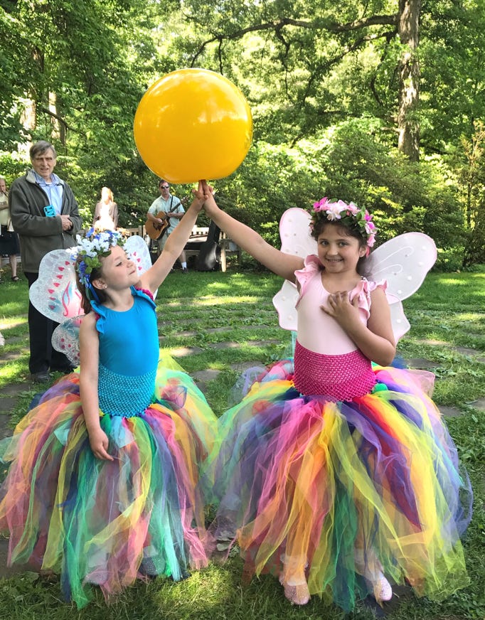 2 girls in fairy costumes with a spinning ball on their fingers